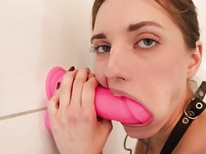 Teenie fuckslut is deep throating a giant rosy fuckfest plaything that's stuck to a wall
